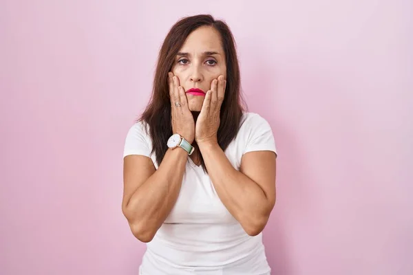 Woman over 50 checking her neck, considering thyroid symptoms